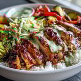 Sliced BBQ Chicken Bowl with fluffy rice, crisp coleslaw, and colorful roasted vegetables on a plate.