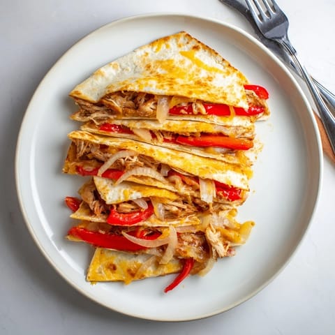 Flavorful Chicken Quesadilla with seasoned grilled chicken, cheddar, and Monterey Jack oozing from a perfectly toasted flour tortilla.