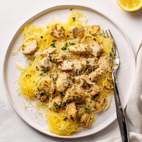 Golden strands of roasted spaghetti squash topped with tender lemon garlic chicken and a generous sprinkle of Parmesan cheese.  