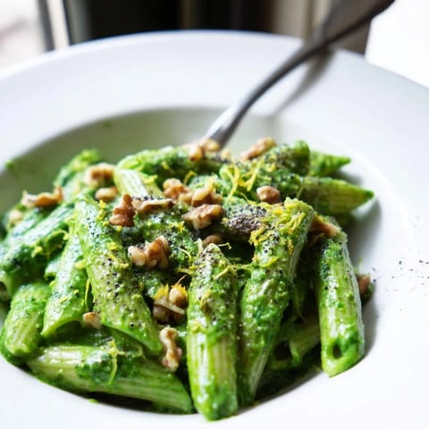 Creamy Spinach Walnut Pasta tossed in a velvety, vibrant green sauce, garnished with chopped walnuts and lemon zest.  