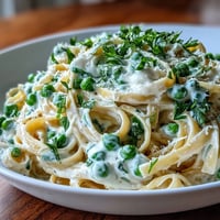 Spring Pasta: Ricotta and Lemon Linguine with Peas in a creamy bowl with fresh herbs and lemon zest.